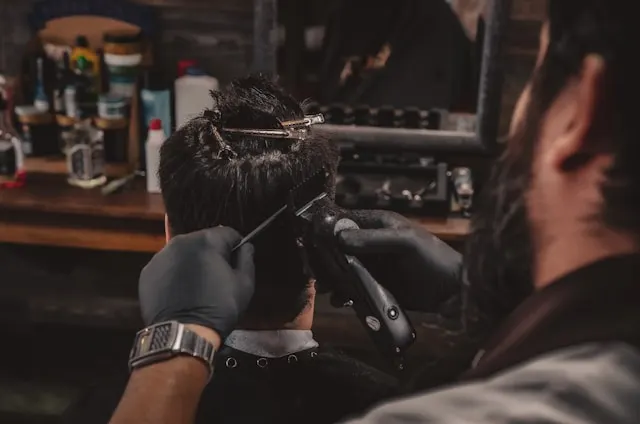 Frisör klipper kund på sin salong, vad tjänar en frisör